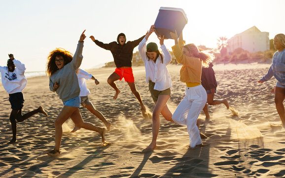 Happy friends having fun on beach in sunset