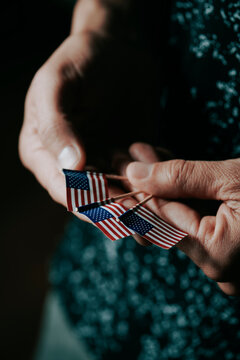 man with mini american flags in his hands