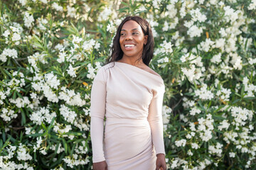 portrait of elegant black woman in a setting full of white flowers