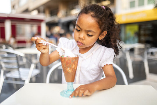 black girl eating ice cream outdoors in the city