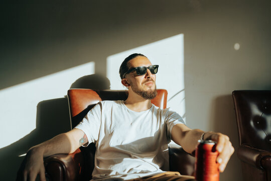 Man in Sunglasses Drinking a beer in the living room
