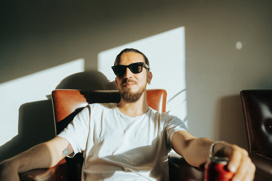 Man with sunglasses possing on a leather couch