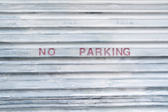 Stock image of NO PARKING sign on garage door