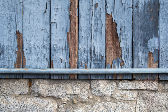 Stock image of building wall, painted wood, stone and metal pipe