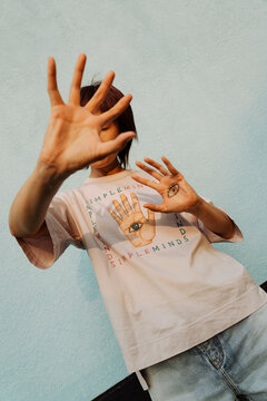 Introspective Vision: Young Woman Reflects with Hand-Painted Design