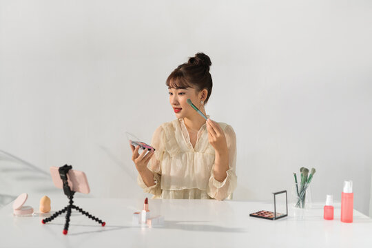 Young woman blogger making a video for her beauty blog on cosmetics.