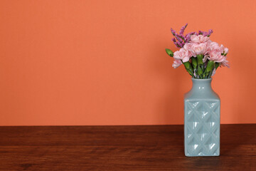 水色の花瓶に活けたスターチスとカーネーションの花束