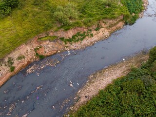 Foto áerea de córrego extremamente poluido, no extremo da zona leste de São Paulo