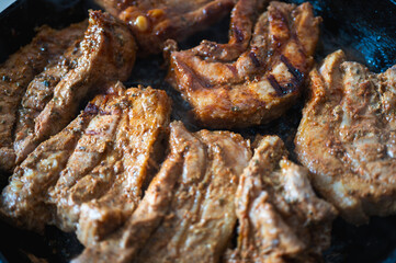 BBQ pork ribs, pork loin with orange sliced with hot honey chili marinade, charred close-up on gray surface