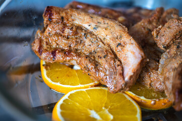 BBQ pork ribs, pork loin with orange sliced with hot honey chili marinade, charred close-up on gray surface