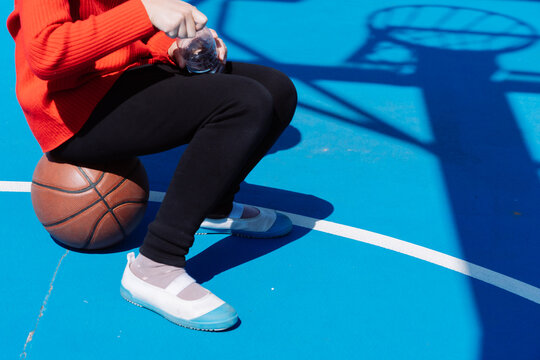 little girl drink water and rest  on the court