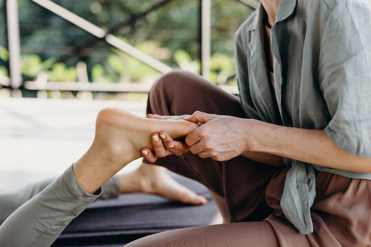Woman giving foot massage to client