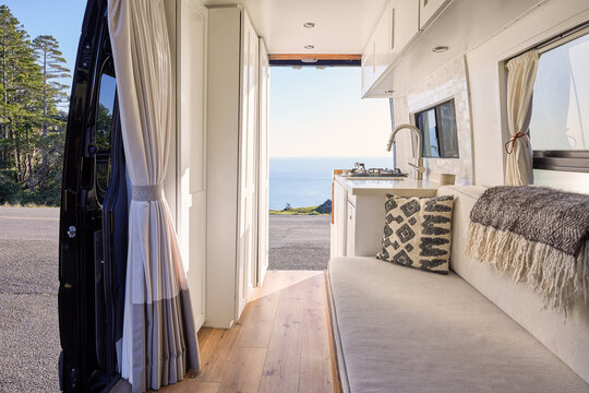 Interior of luxury Sprinter camper van kitchen in nature view of ocean