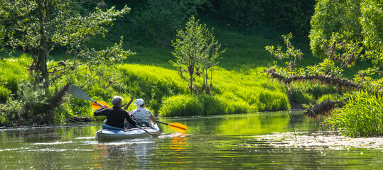 Family kayak trip for seigneur and senora. An elderly married couple rowing a boat on the river, a...