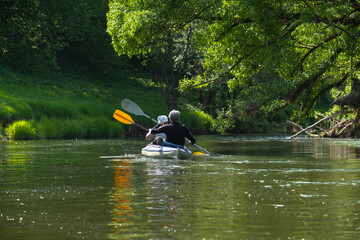 Family kayak trip for seigneur and senora. An elderly married couple rowing a boat on the river, a water hike, a summer adventure. Age-related sports, mental youth and health, tourism, active old age