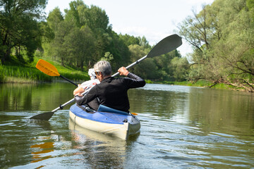 Family kayak trip for seigneur and senora. An elderly married couple rowing a boat on the river, a water hike, a summer adventure. Age-related sports, mental youth and health, tourism, active old age