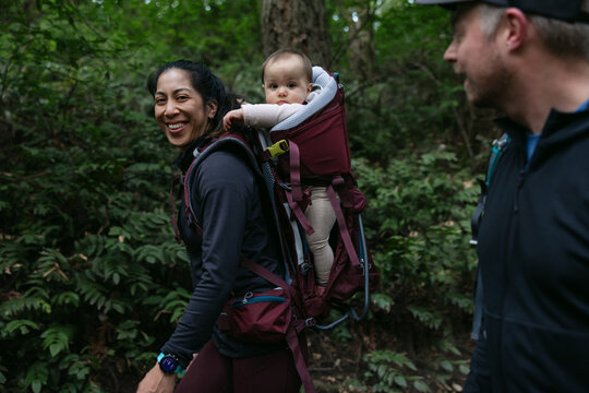 Woman smiling with baby in carrier.
