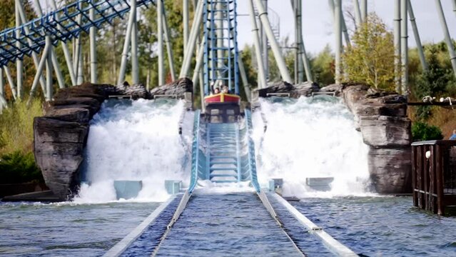 Battrupholtve, Nimtofte , Danmark - 12 26 2022: Crush down in water from water roller coaster in amusement park. Spray. Attraction. Entertainment, Boat floats on water roller coaster in amusement park