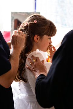 Family helping the girl for her first communion.