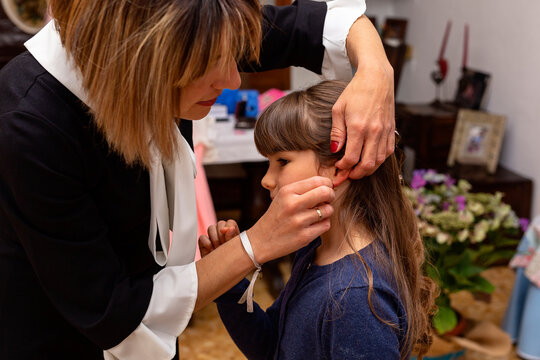 Mother preparing her daughter to take her first communion