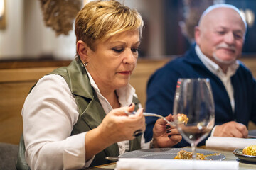 Mature couple eating food in restaurant