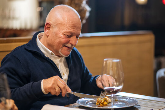 Middle aged male enjoying food in restaurant