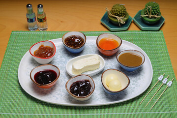 Turkish breakfast table. Pastries, vegetables, greens, olives, cheeses, fried eggs, jams, honey, tea in copper pot and tulip glasses, wide composition