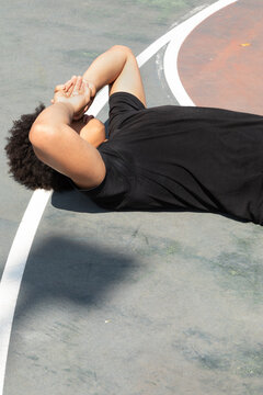 Teenager hanging out on a basketball court outdoors