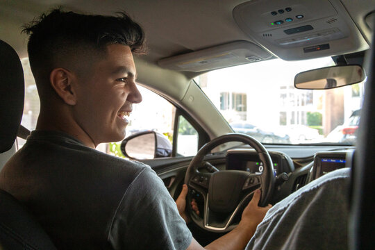 Latinx father teaching his son to drive 
