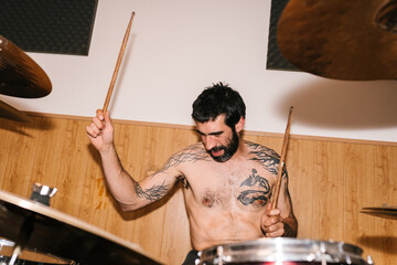 Bearded man playing drums in studio