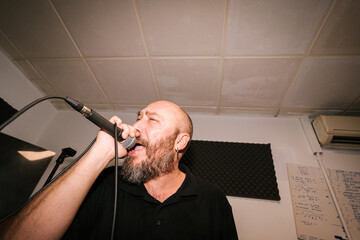 Bearded male musician singing into microphone