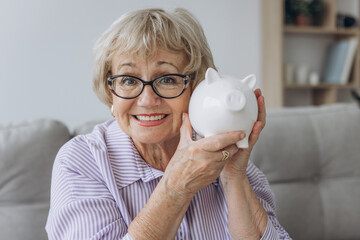 savings, money, annuity insurance, retirement and people concept - smiling senior woman putting...