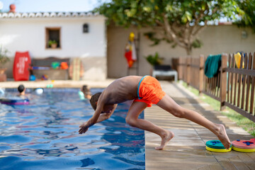 Kid jumping in swimming pool with water