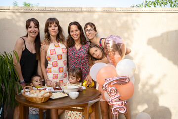 Happy mothers with kids during birthday party 