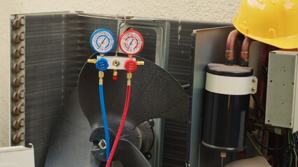 Close up shot of manifold indicators used for checking condenser refrigerant in need of fixing. Set...