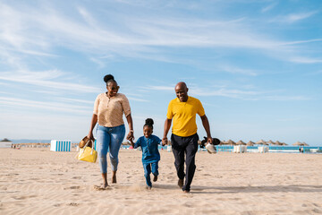 Happy black family strolling on beach