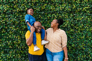 Happy family standing near green bush