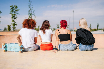 Back shot of teenagers sharing moments together in a skatepark