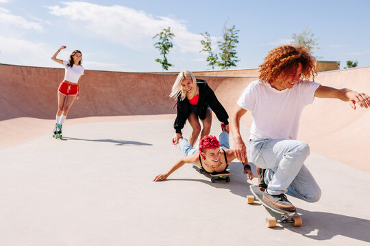 Group of teenagers playing the fool and having fun  in the skatepark