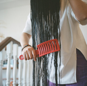 The woman is combing her long hair

