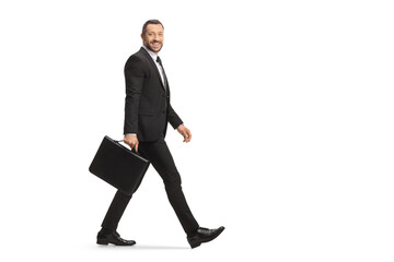 Full length shot of a businessman walking with a briefcase and smiling