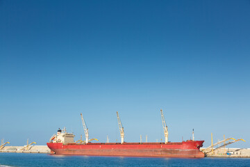 Industrial cargo ship berthed at the port, loading ore