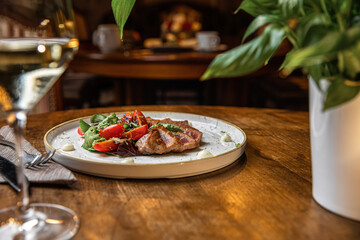 Fototapeta na wymiar Cooked juicy tuna steak with vegetables on a plate. Restaurant food. Seafood. Rustic style.