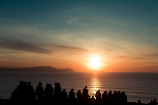 Family and friends enjoying sunset sea view