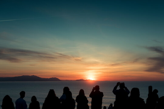 Group of people enjoying sunset sea view