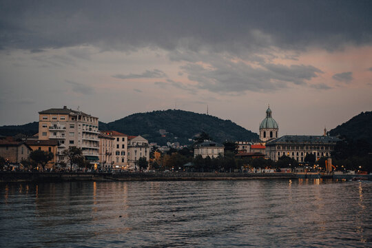 Serene sunset over Como Lake with twinkling city lights