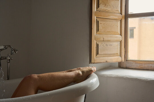 Relaxed female legs in bathtub.