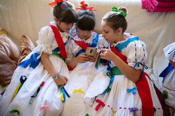Friends in traditional costume playing with mobile phone
