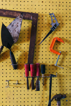 Hardware Tools hanging in Garage workshop on Yellow pegboard 