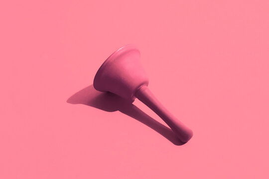 A pink bell on a pink background. Monochromatic composition